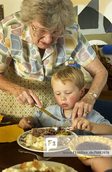 Lebensmittel schneiden Hilfe Großmutter Enkelsohn