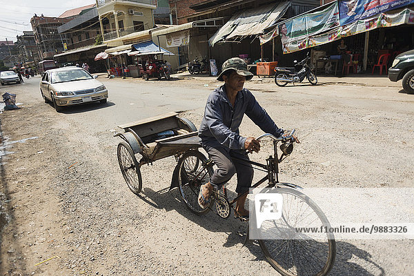'A man riding his bicycle and cart around Old market; Battambang  Cambodia'