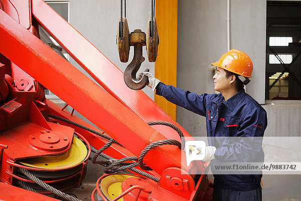 Arbeiter mit Geräten in der Kranfertigung  China
