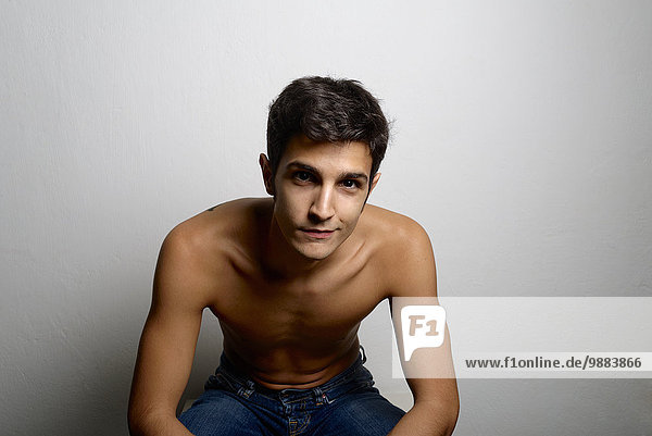 Studio portrait of confident bare chested young man