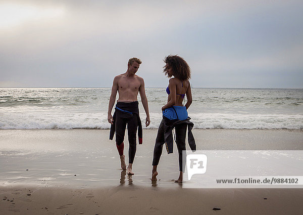 Handsome young surfing couple on beach  Playa Del Rey  California  USA