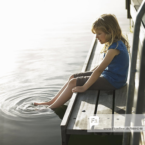 Mädchen tauchende Füße im See