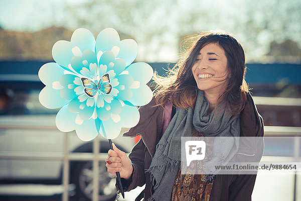 Mittlere erwachsene Frau mit Blumenwindmühle
