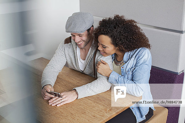 Mann und Frau schauen auf Smartphone