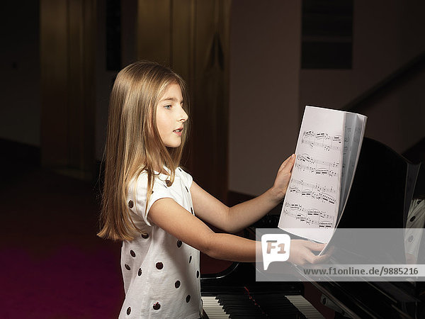 Mädchen wählen Noten für Klavier