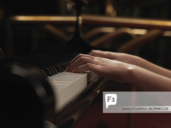 Nahaufnahme von Mädchenhänden beim Klavierspielen