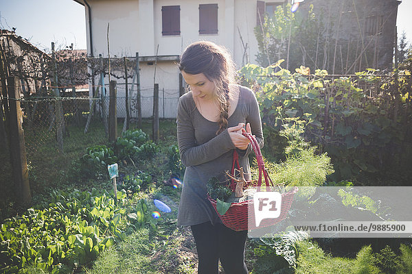Young woman holding basket in garden