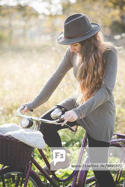 Young woman wearing hat on bicycle