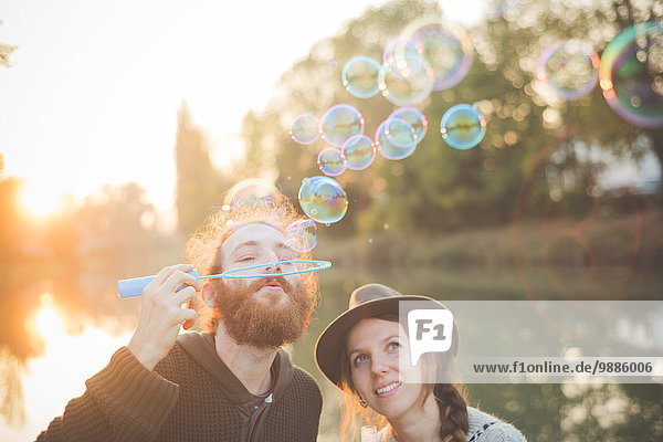 Young couple blowing bubbles