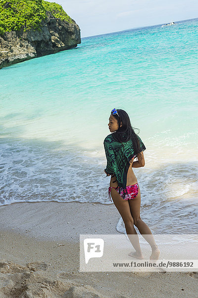 Young woman enjoys walking on the sand of Puka beach; Borakay  Panay  Philippines
