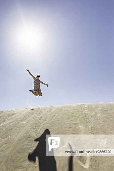 Junge Frau springt in der Luft  Dune de Pilat  Frankreich