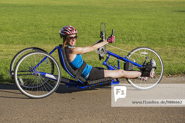 Woman with spinal cord injury cycling using hand propelled bicycle; Edmonton  Alberta  Canada