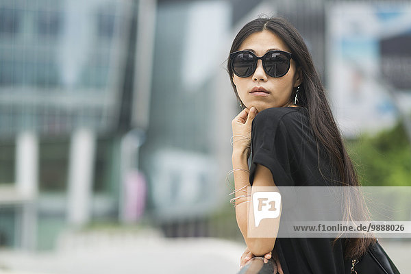 Portrait of a young woman with long brunette hair and sunglasses; Xiamen  China