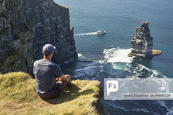 Stapel Felsbrocken sitzend Mann Ecke Ecken Gebäude Ozean Tagesausflug Boot Meer Ignoranz groß großes großer große großen Wiese Clare County Irland Felssäule