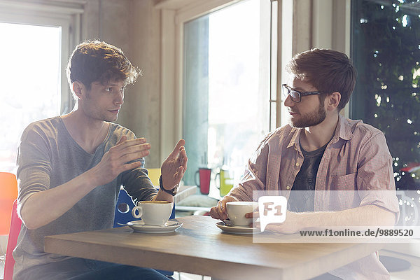 Männer reden und trinken Kaffee im Cafe