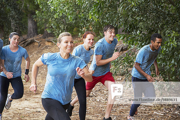 Lächelndes Team läuft auf dem Bootcamp-Hindernisparcours