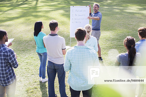 Man leading meeting at flipchart in field