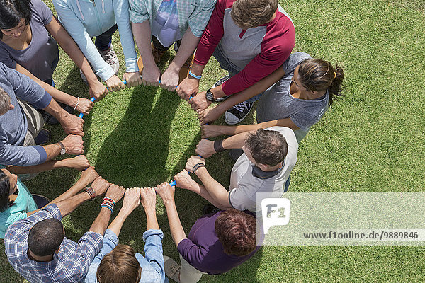Group connected in circle around plastic hoop