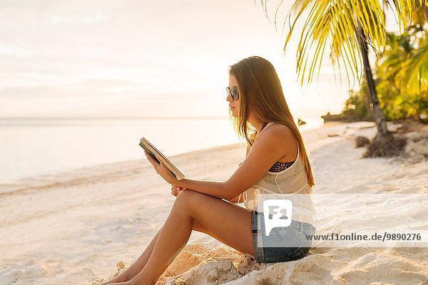 Junge Frau liest Buch am Strand von Anda  Provinz Bohol  Philippinen