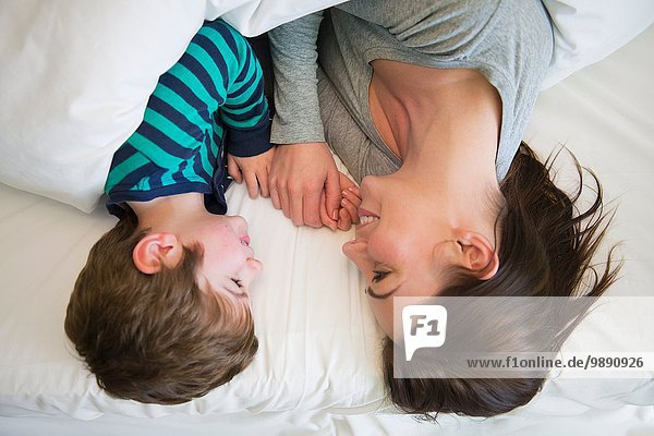 Mother and son relaxing together in bed  overhead view