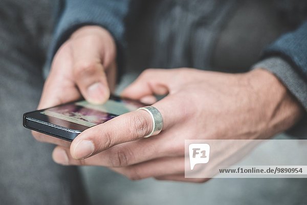 Nahaufnahme des Geschäftsmannes Hände SMS auf dem Smartphone