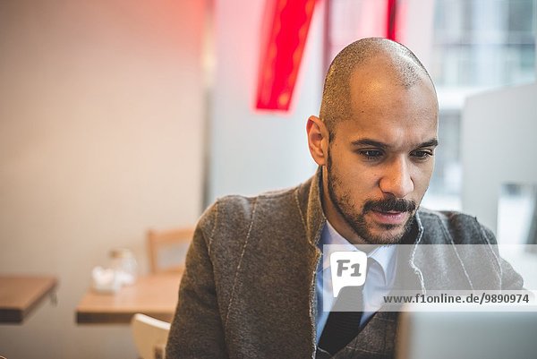 Businessman sitting in cafe using laptop