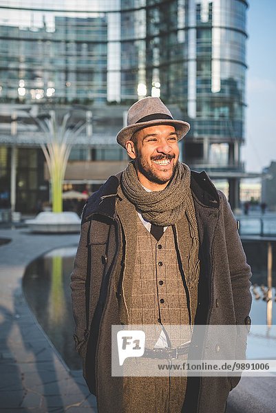 Lächelnder Geschäftsmann vor dem Bürogebäude