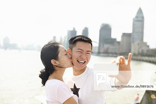 Affectionate tourist couple taking smartphone selfie  The Bund  Shanghai  China