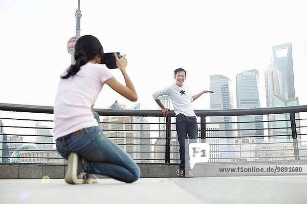 Männliche Touristen posieren für Freundin mit Sofortbildkamera  The Bund  Shanghai  China