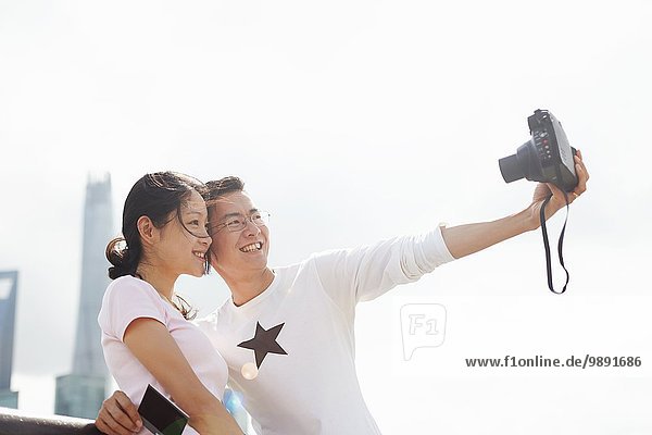 Tourist couple taking instant camera selfie  The Bund  Shanghai  China