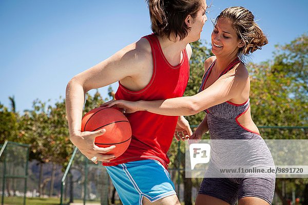 Young couple flirting on basketball court