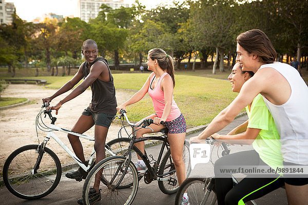 Young adults preparing to cycle in park