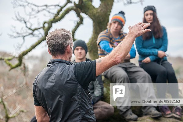 Male instructor talking to group of rock climbers