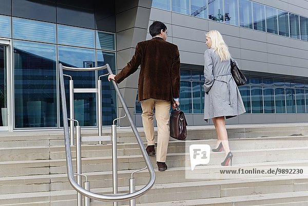 Geschäftsmann und Geschäftsfrau  gemeinsam die Treppe hinaufgehen  Rückansicht