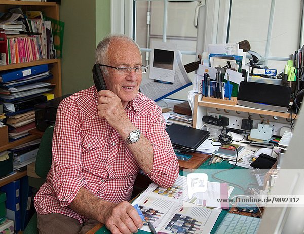 Senior man on phone in home office