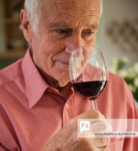 Mann riecht nach Glas Rotwein