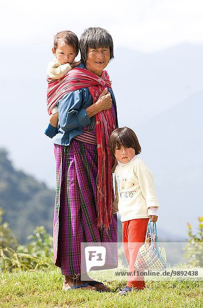Portrait of Bhutanese woman and two children on hill  Timpu  Bhutan