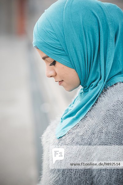 Nahaufnahme Porträt einer jungen Frau mit türkisfarbenem Hijab auf dem Steg