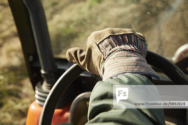 Nahaufnahme der männlichen Hand fahren Traktor Milchviehbetrieb Feld