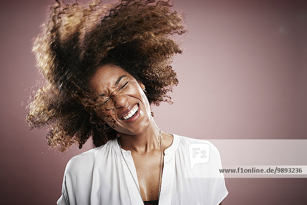 Porträt einer jungen Frau  die Haare schnippt  lächelnd