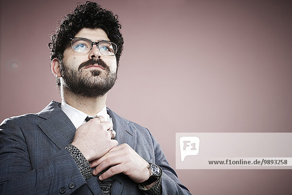 Portrait of young man adjusting tie