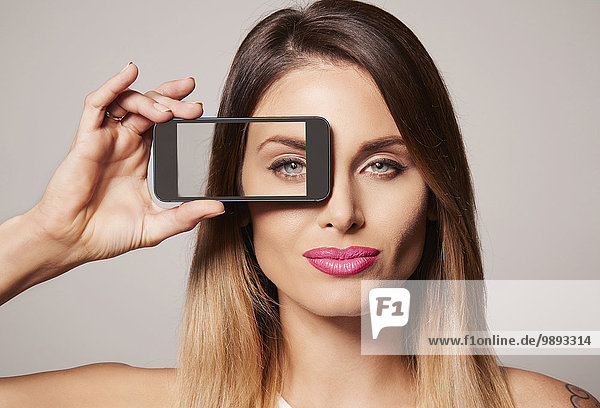 Woman holding up frame to eye
