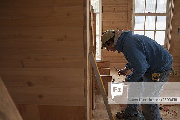 Mature man building wooden staircase in house