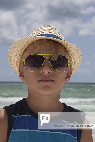 Portrait des Jungen mit Strohhut und Sonnenbrille am Strand  Anna Maria Island  Florida  USA
