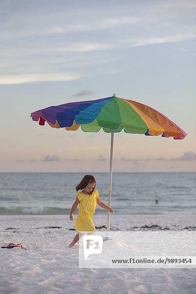 Mädchen läuft am Strand um den bunten Sonnenschirm  Anna Maria Island  Florida  USA
