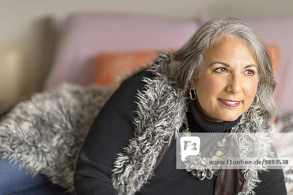Mature woman relaxing on bed