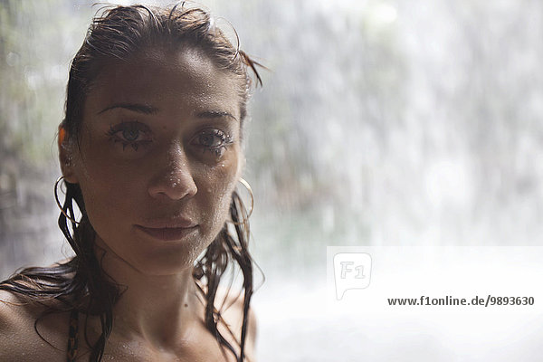 Frau mit nassem Haar  Wasserfall im Hintergrund