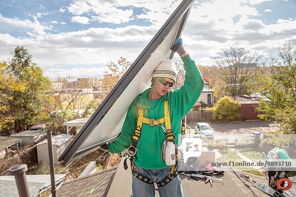 Baumannschaft mit Solarmodul auf dem Dach des Hauses