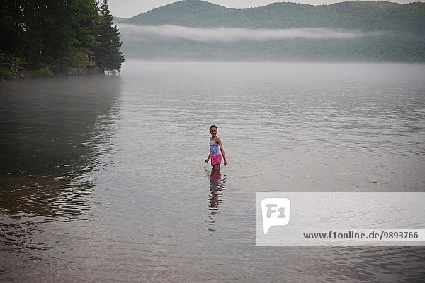 Ein Mädchen steht im Wasser im Sommerurlaub am Lake George  New York  USA