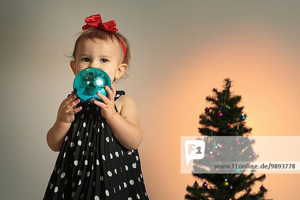 Kleines Mädchen mit Weihnachtskugel